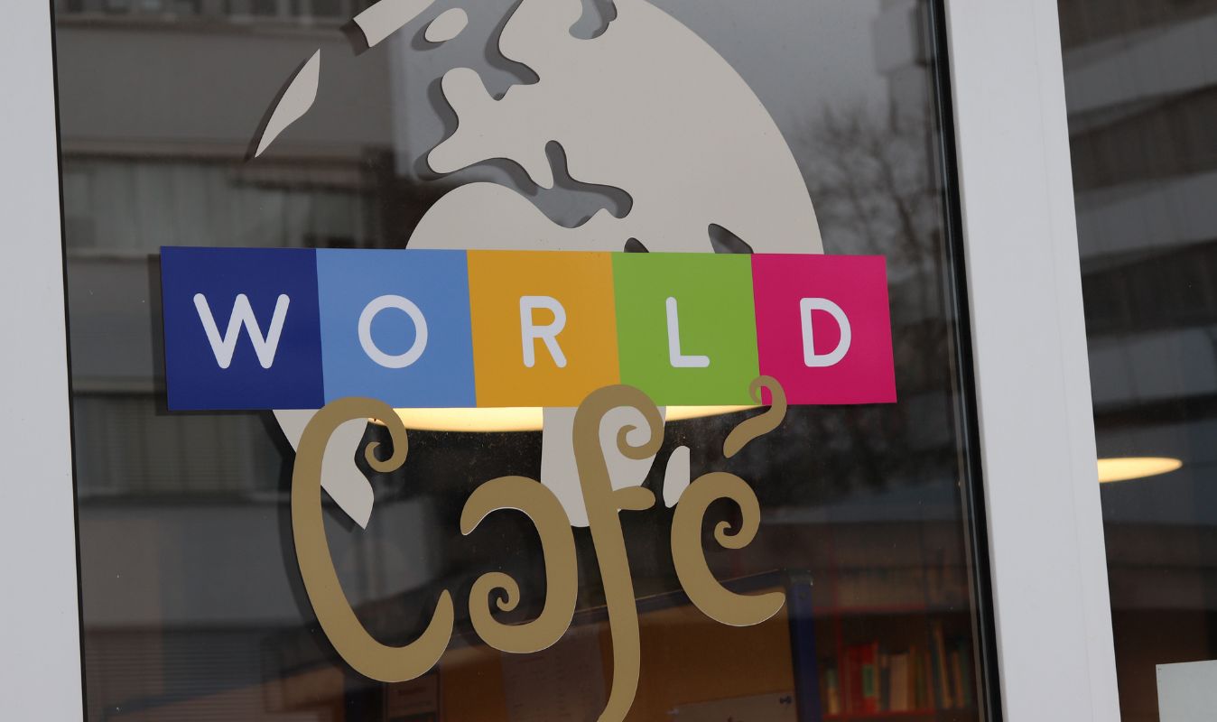 Logo des World Café auf der Fensterscheibe